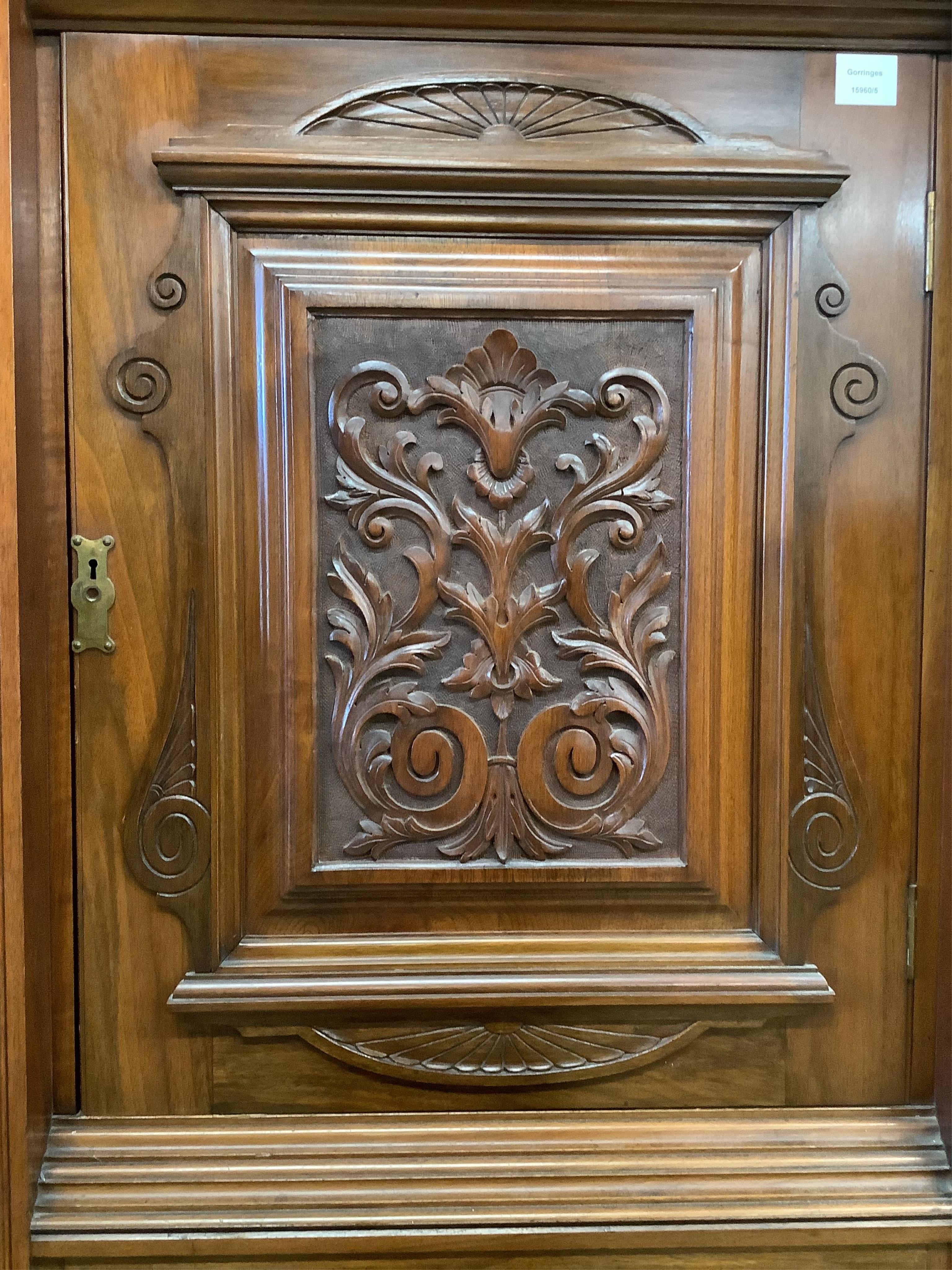 A late Victorian carved walnut mirrored compactum wardrobe, width 186cm, depth 56cm, height 227cm. Condition - good